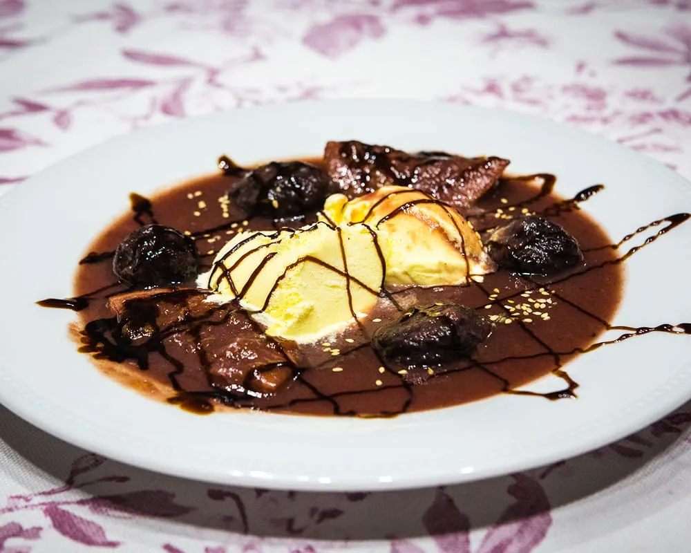 Ciruelas pasas en arrope con helado de yema.
